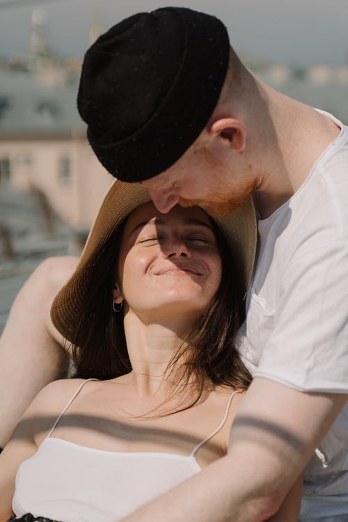 白衬衫的男人亲吻棕色帽子的女人 · 免费素材图片