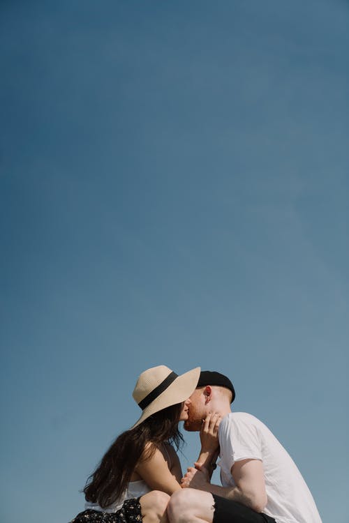 蓝蓝的天空下戴棕色帽子的白衬衫的男人 · 免费素材图片