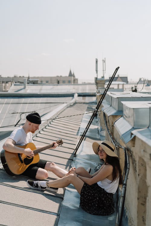 2名妇女坐在白色和棕色的船上弹吉他 · 免费素材图片