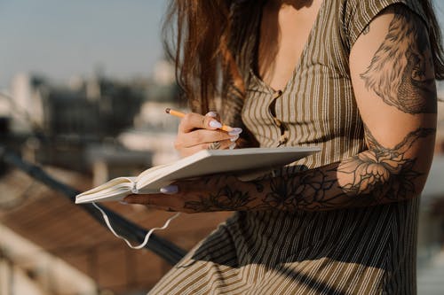 黑色和白色条纹长袖衬衫阅读书中的女人 · 免费素材图片