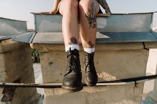 坐在白色的混凝土长凳上的黑色皮靴的女人 · 免费素材图片
