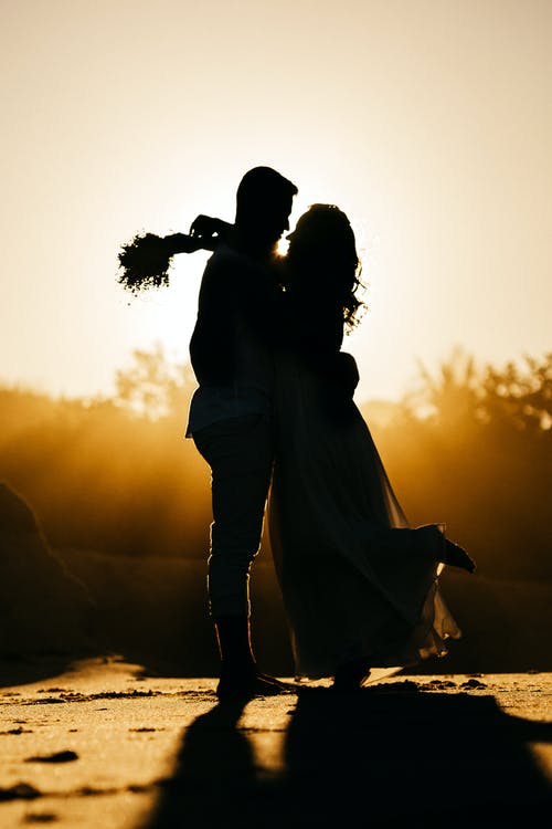 浪漫的情侣拥抱和在海滩上享受日落 · 免费素材图片