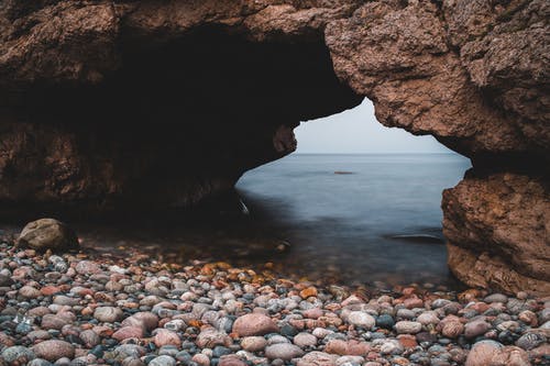 和平的圆石滩与岩石拱门 · 免费素材图片