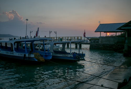 日落时分，船停泊在湖岸 · 免费素材图片
