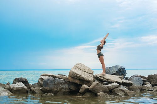 灵活的女人在石头上表演瑜伽 · 免费素材图片