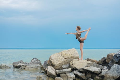 灵活的女人在海洋海岸上执行瑜伽 · 免费素材图片