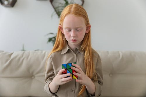 思考明亮的难题立方体的逗人喜爱的女孩 · 免费素材图片
