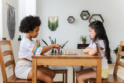 多民族体贴的女孩在现代居室下棋 · 免费素材图片