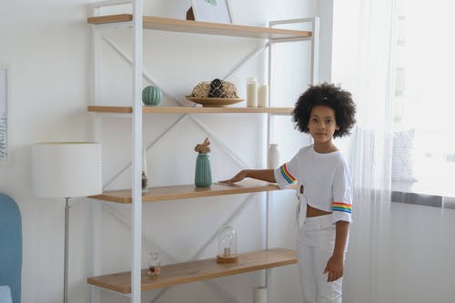小黑人女孩清洗自己房间里的架子 · 免费素材图片