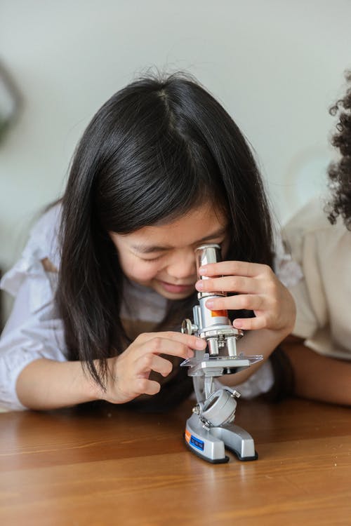 好奇的族裔孩子在工作室里检查化学仪器 · 免费素材图片