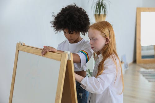 重点放在画架黑板上绘画的各种儿童 · 免费素材图片
