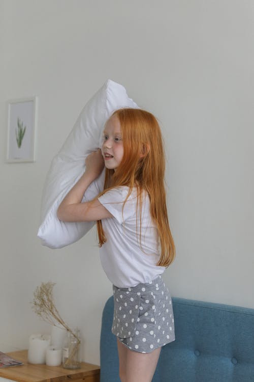 小女孩玩在卧室里的枕头 · 免费素材图片