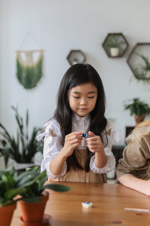 集中在桌上玩的小女孩 · 免费素材图片