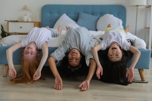 躺在床上的快乐多种族的小女孩 · 免费素材图片
