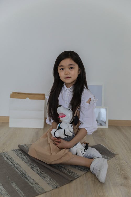 快乐的亚洲小女孩坐在地板上 · 免费素材图片