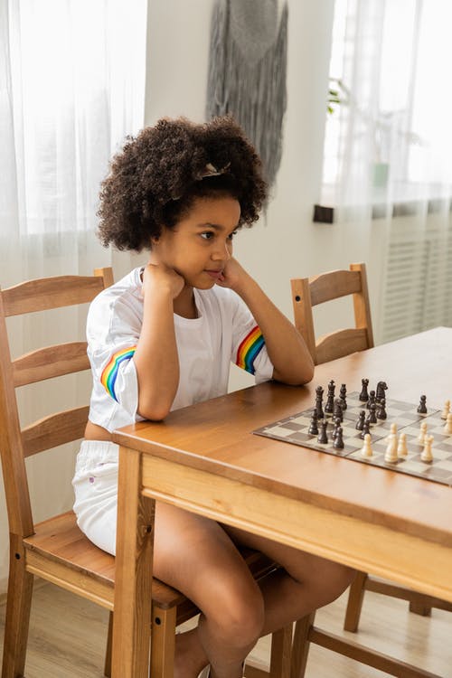 在白天在桌上下棋的黑人女孩 · 免费素材图片