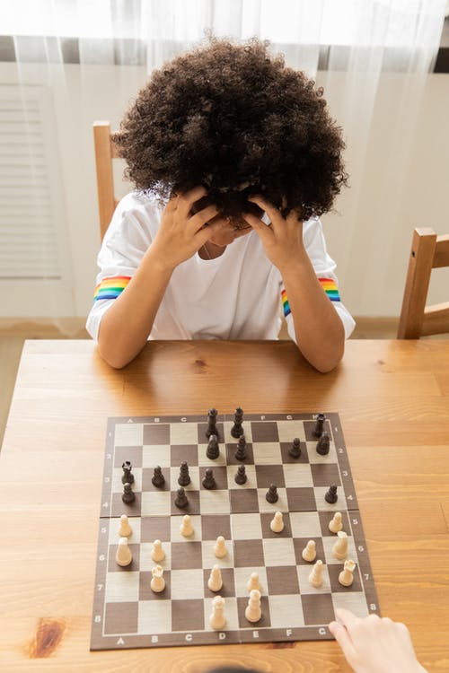 思考在棋chess的黑人女孩在桌上 · 免费素材图片