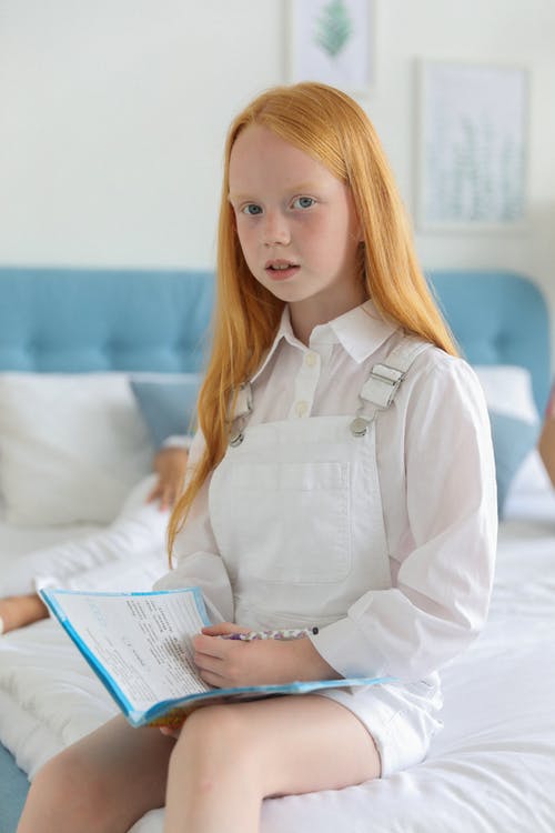 可爱的小女孩用铅笔做作业 · 免费素材图片