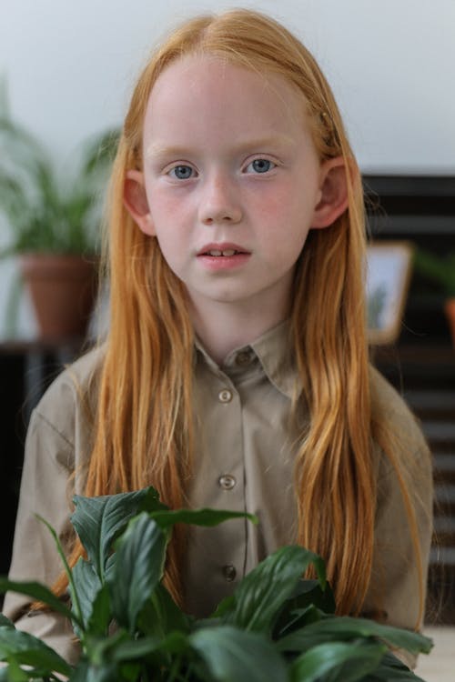 有植物的迷人的小女孩在家 · 免费素材图片