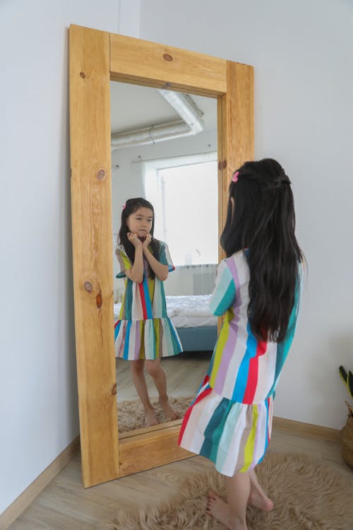 亚洲女孩在镜子与木制框架欣赏 · 免费素材图片