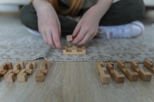 庄稼女孩在地毯上玩积木 · 免费素材图片