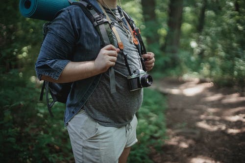 用相机在树林里的路径上作物徒步旅行者 · 免费素材图片