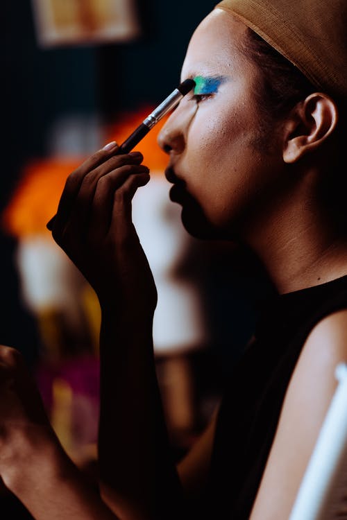 作物民族女演员在眼皮上应用明亮的眼影 · 免费素材图片