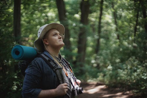 梦幻般的男性游客与远足设备探索绿色森林 · 免费素材图片