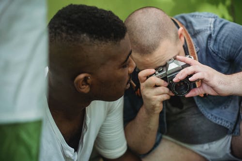 和黑人朋友一起徒步旅行时在相机上拍照的人 · 免费素材图片