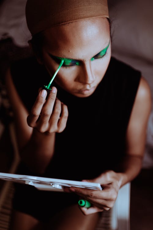 作物在眼皮上应用绿色眼影的族裔女人 · 免费素材图片