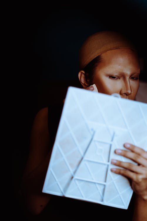 亚洲女人传播胭脂和荧光笔在脸上 · 免费素材图片