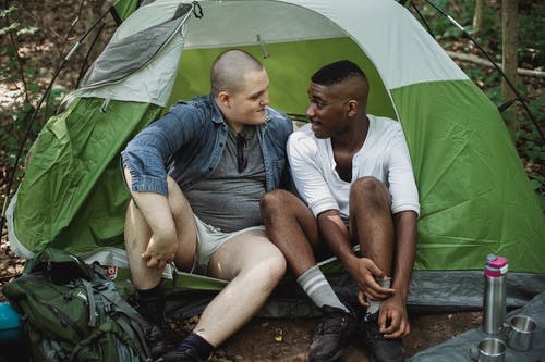 男性多样的朋友在森林里的帐篷里休息 · 免费素材图片