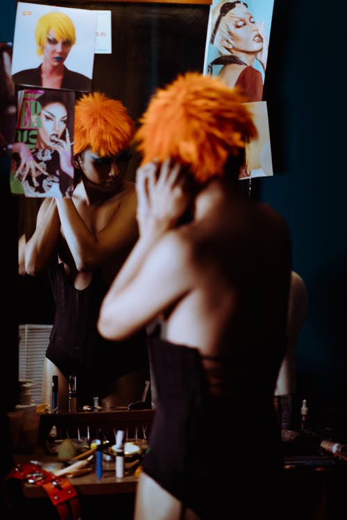 调整橙色假发的非正式妇女反对镜子 · 免费素材图片
