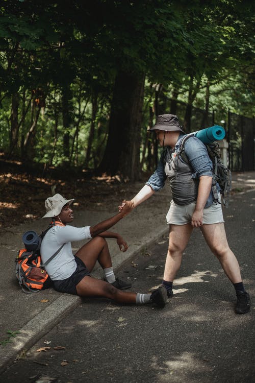 徒步旅行者在路上握着黑人朋友的手 · 免费素材图片