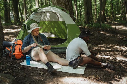 旅行的朋友享受在森林露营在阳光灿烂的日子 · 免费素材图片
