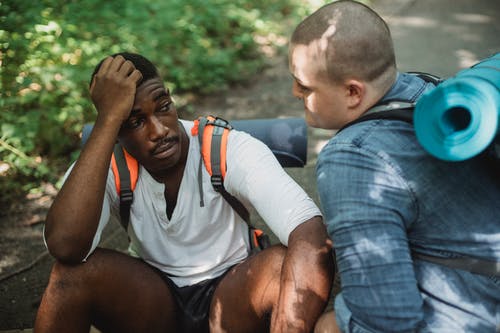 沮丧的黑人男子和朋友一起旅行时交谈 · 免费素材图片