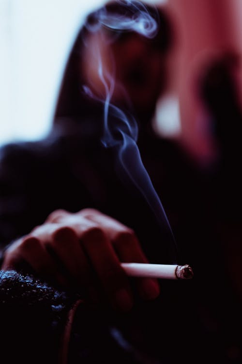 无法识别的女人在房间里抽烟 · 免费素材图片