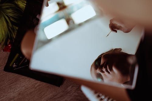 作物民族女人与化妆施药器反映在镜子里 · 免费素材图片