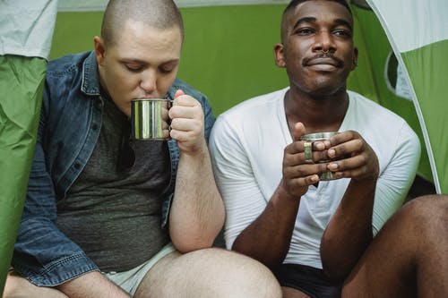男性多样的朋友在帐篷里喝茶 · 免费素材图片