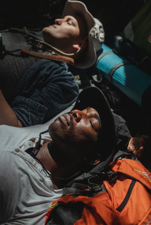 周末在背囊上睡觉的多样男性徒步旅行者 · 免费素材图片