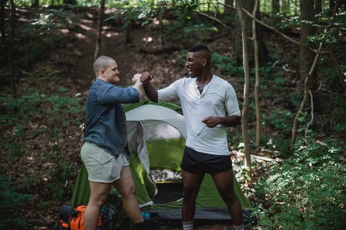 快乐的人，在森林里的帐篷附近 · 免费素材图片