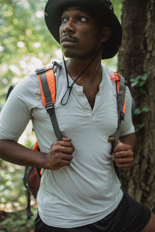 在森林里种着背包的梦幻般的黑人旅行者 · 免费素材图片