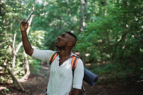 聚焦在森林中寻找联系的黑人旅行者 · 免费素材图片