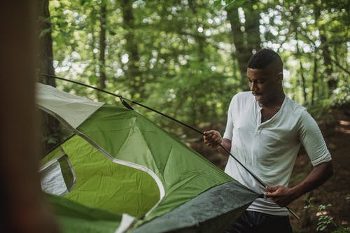 把帐篷放在森林里的快乐黑人 · 免费素材图片