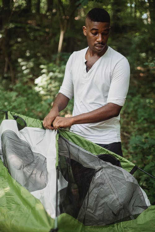 非洲裔美国人把露营帐篷放在森林里 · 免费素材图片