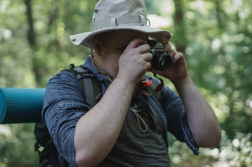 无法识别的徒步旅行者在树林里的相机拍照 · 免费素材图片