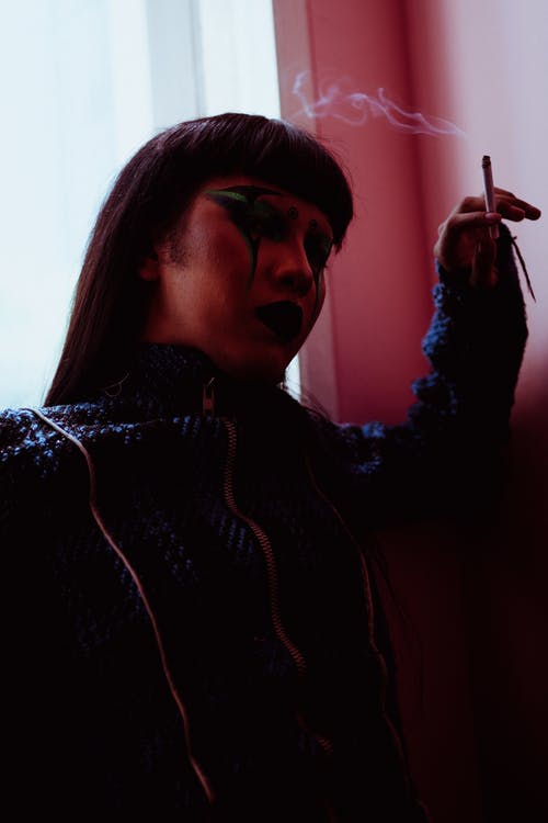 在房间里吸烟的亚裔女子 · 免费素材图片