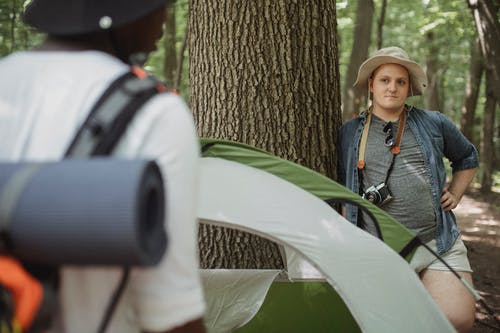 旅行者用相机在森林中无法识别的黑伙伴附近 · 免费素材图片