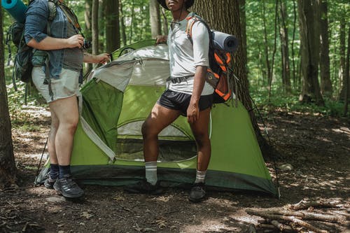 旅行的朋友在森林露营帐篷附近休息 · 免费素材图片