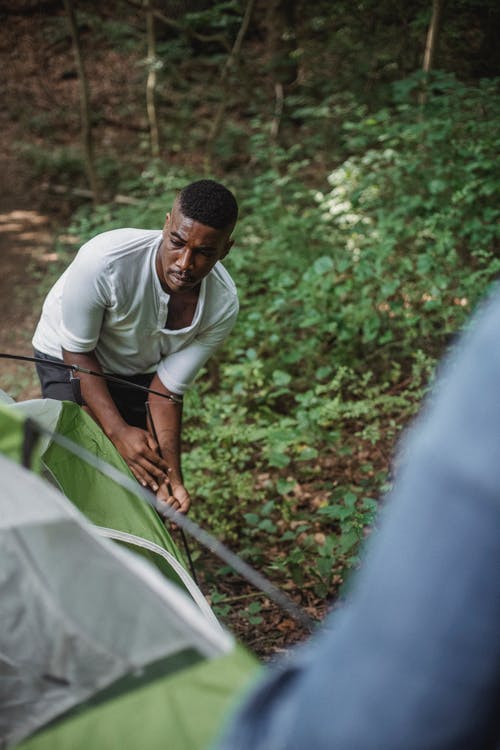 黑人把帐篷放在森林里 · 免费素材图片
